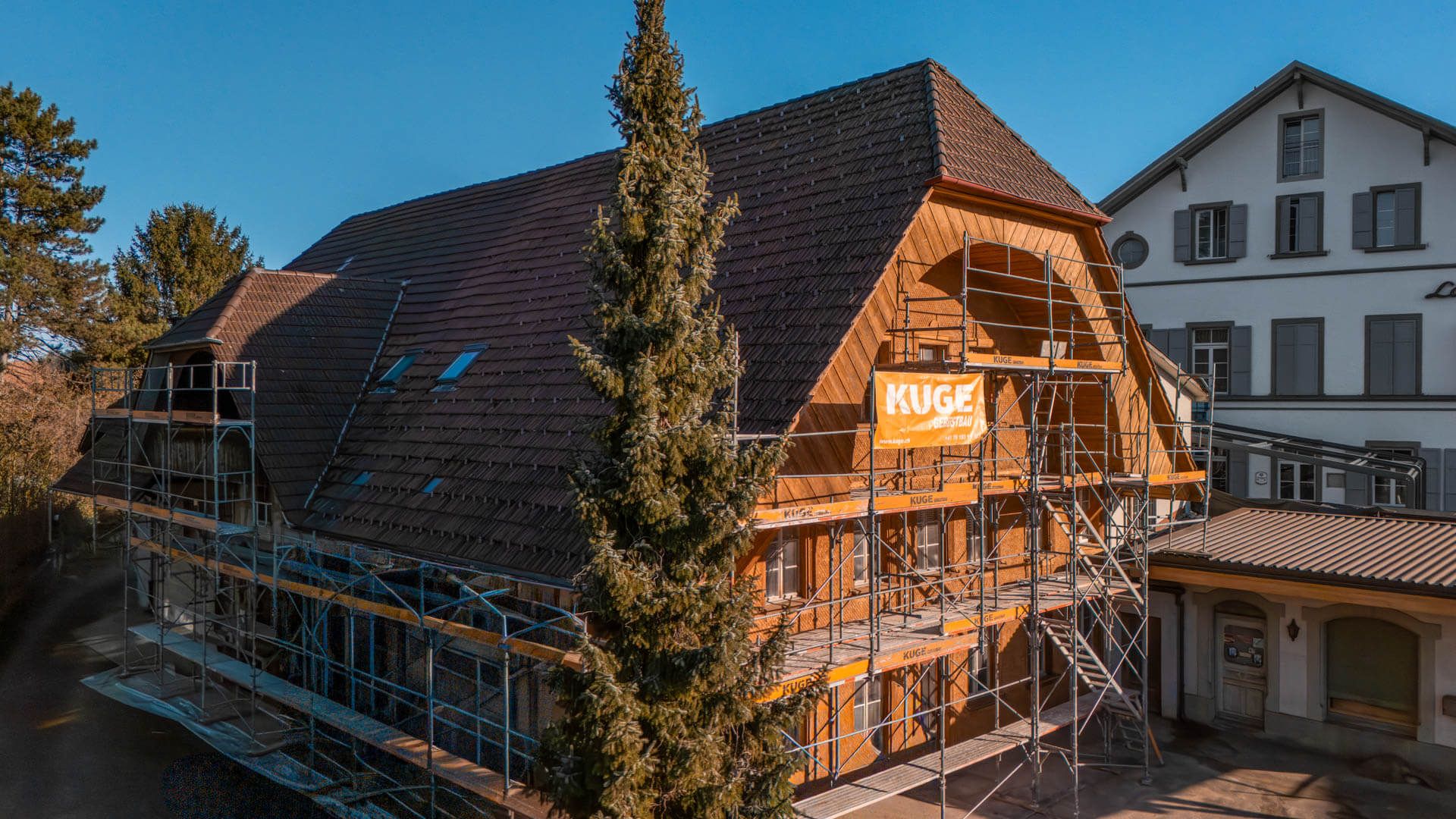 Eingerüstetes Wohnhaus mit durchgehenden Gerüstlagen und Seitenschutz – Foto: KUGE Bau AG